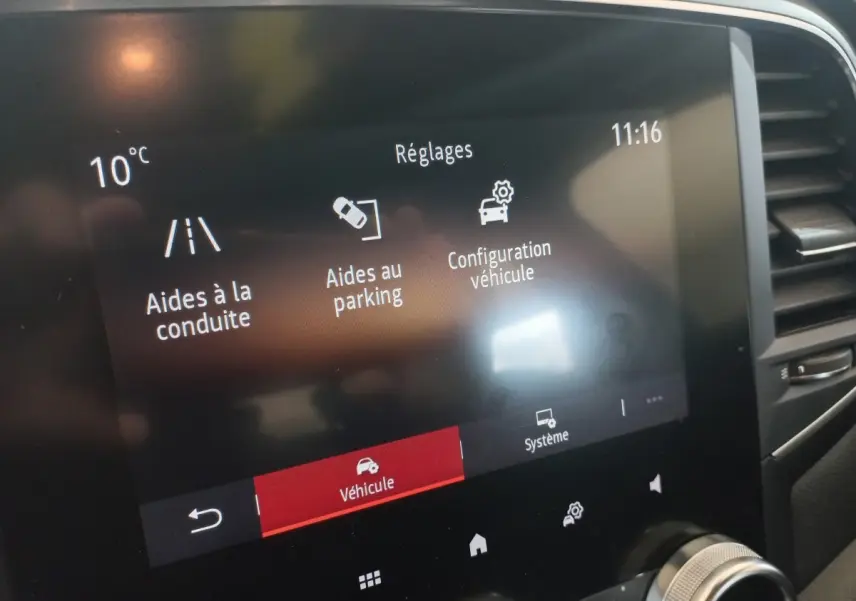 Écran tactile central de la Renault Mégane Business gris foncé affichant les réglages d’aides à la conduite et au parking.