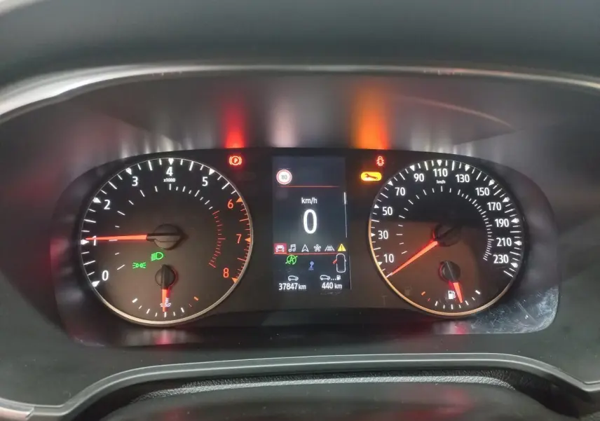 Tableau de bord de Renault Mégane Business TCe 115, affichage numérique central et compteurs analogiques éclairés.