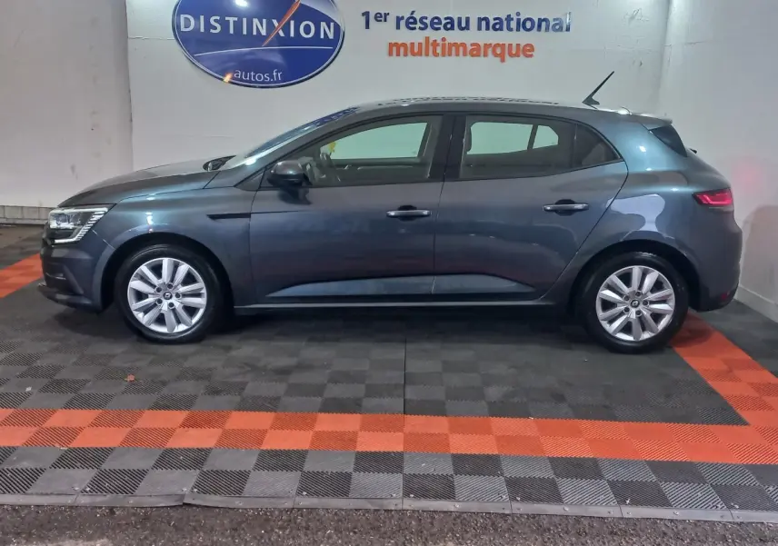 Renault Mégane Business TCe 115 gris foncé vue de profil côté gauche, en intérieur sur sol damier noir et orange.