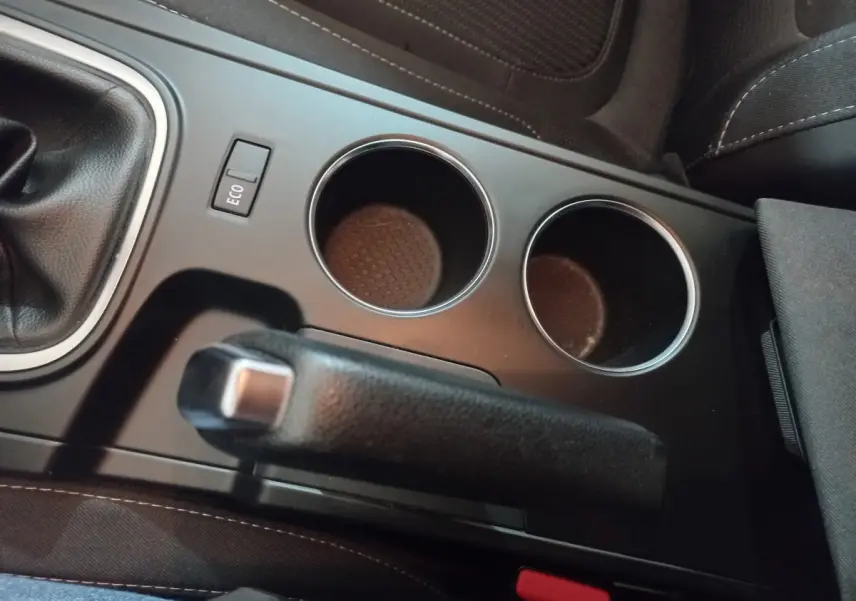 Vue rapprochée de la console centrale grise foncée de la Renault Mégane Business, avec frein à main et porte-gobelets.