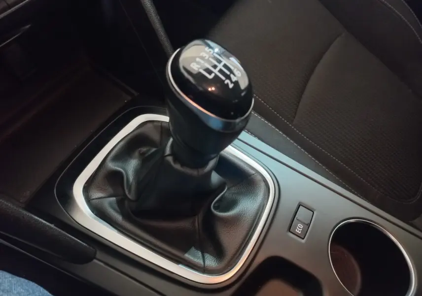 Gros plan sur le levier de vitesses manuel noir de la Renault Mégane Business gris foncé, avec bouton ECO à côté.