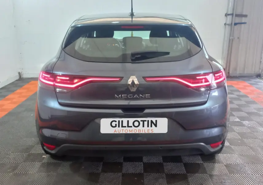 Vue arrière d'une Renault Mégane Business gris foncé avec feux LED allumés dans un garage.