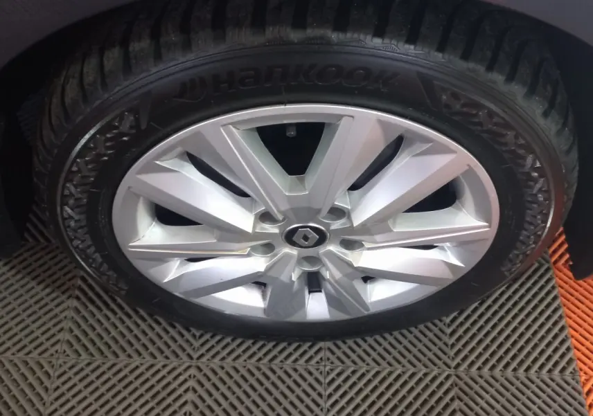 Gros plan sur la roue avant gauche de la Renault Mégane Business gris foncé avec jante alliage argentée et pneu Hankook.