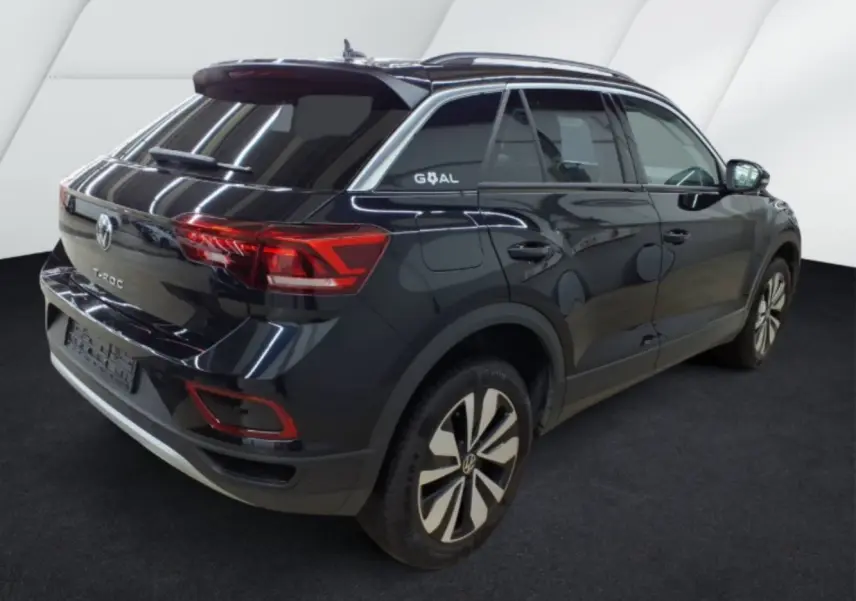 Volkswagen T-Roc noir vue 3/4 arrière droit, avec jantes stylisées et sticker Goal sur la vitre arrière.