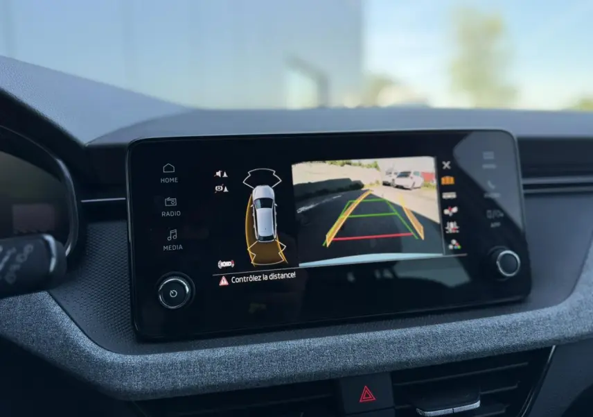 Écran tactile intérieur de la Skoda Scala blanc Glacier affichant la caméra de recul avec guidage dynamique.