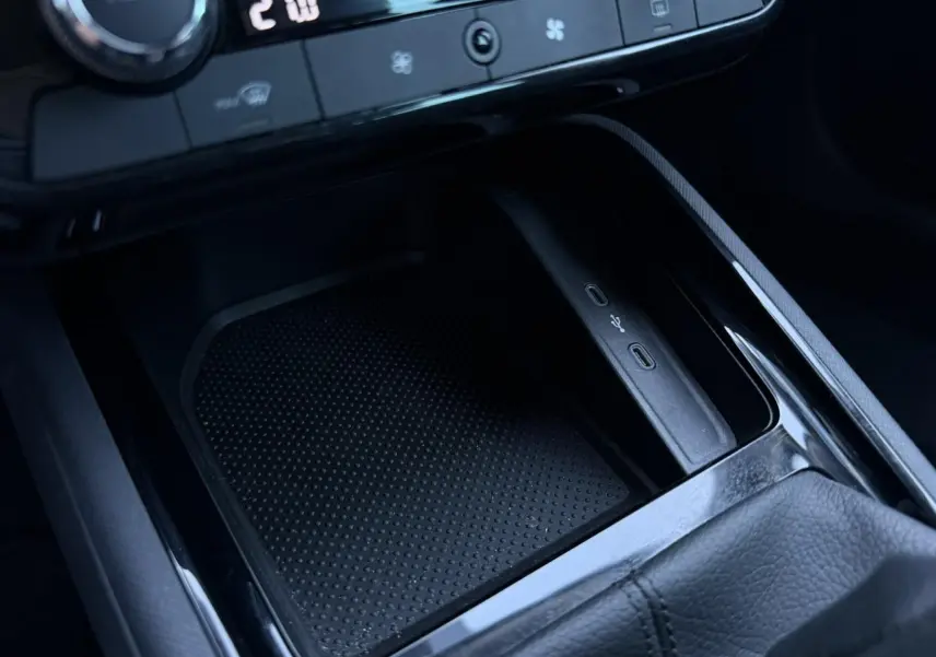 Gros plan sur la console centrale noire du Skoda Scala blanc, avec ports USB-C et commande de climatisation visible.