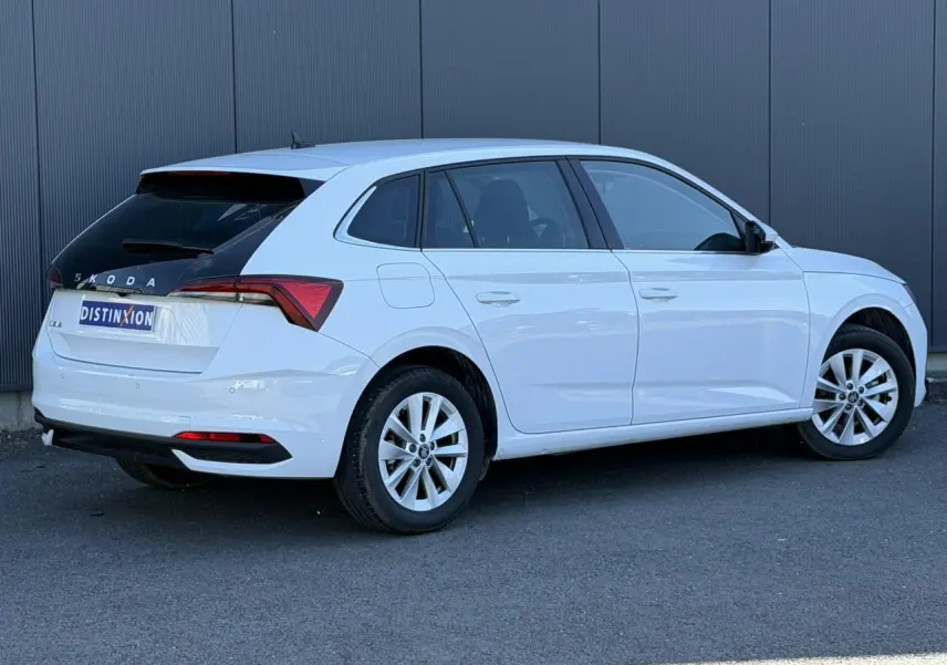 Vue 3/4 arrière droite d'une Skoda Scala blanc glacier avec lunette arrière surteintée et jantes alliage 16 pouces.