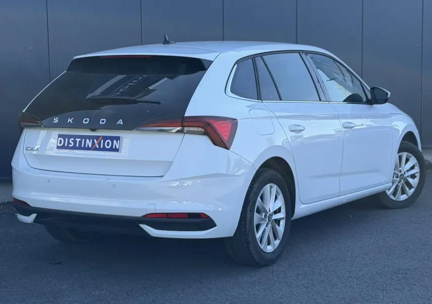 Vue 3/4 arrière droite d'une Skoda Scala blanc glacier avec lunette arrière surteintée et jantes alliage 16 pouces.