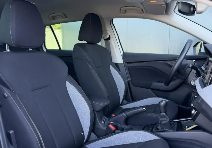 Vue intérieure côté droit de la Skoda Scala TSI 116, sièges tissu noir et gris avec surpiqûres blanches.