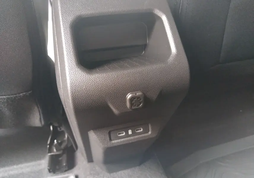 Détail de la console arrière noire du Dacia Duster Hybrid-G 150 ch, avec prises USB-C visibles en bas.