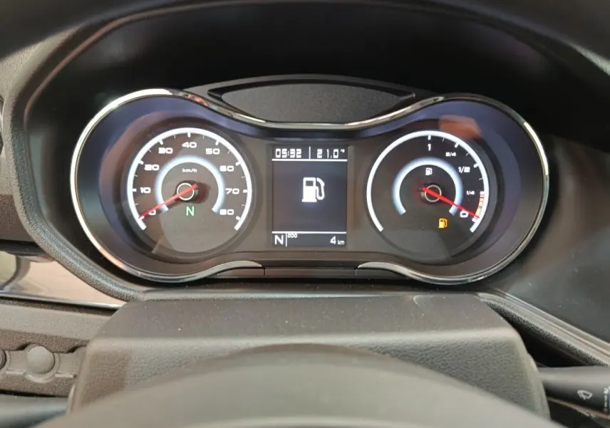 Vue rapprochée du tableau de bord de l'AIXAM AMBITION 0.5 City Coupe Sport montrant les compteurs et l'alerte de carburant.