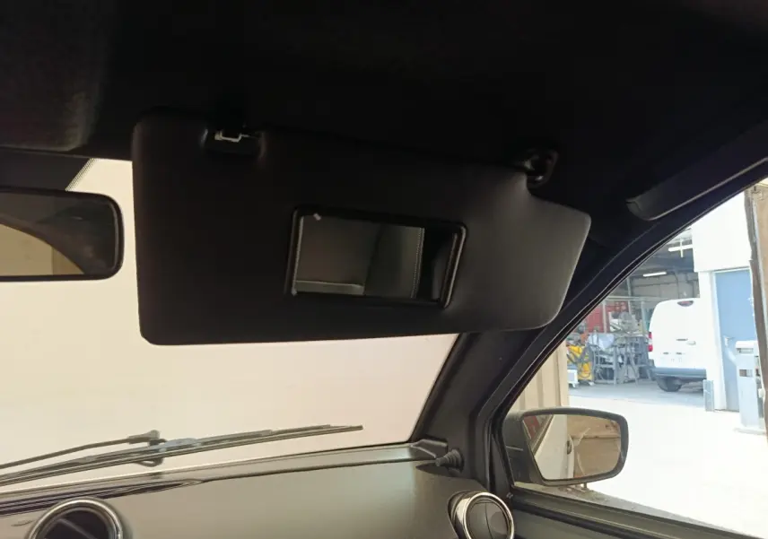 Vue intérieure côté conducteur de l'AIXAM AMBITION 0.5 City Coupe Sport 2026, montrant le pare-soleil et le rétroviseur extérieur.