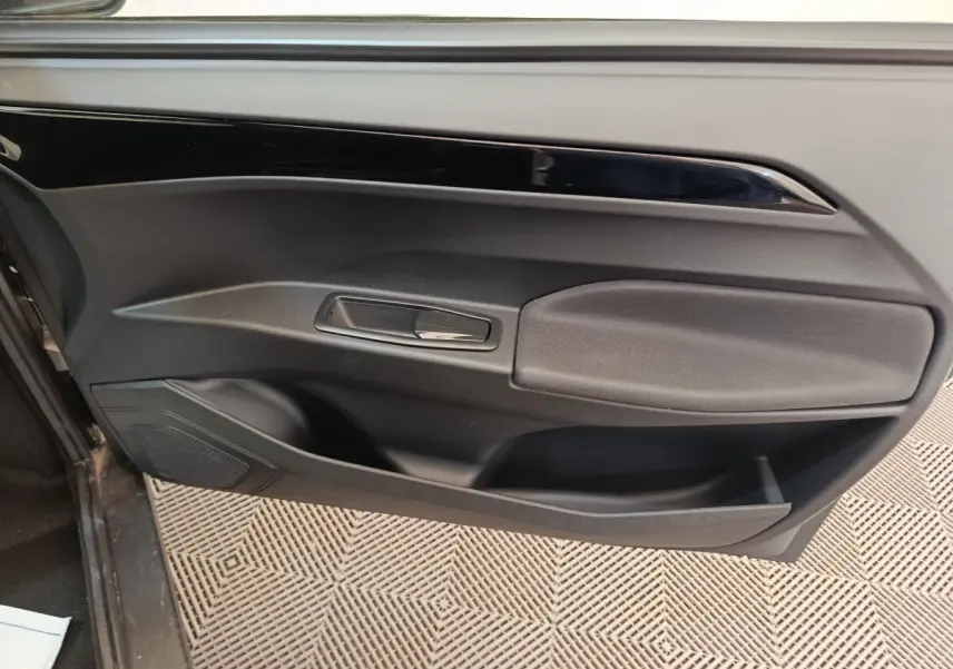 Vue intérieure en gros plan de la porte côté gauche noire de l'AIXAM AMBITION 0.5 CITY COUPE SPORT blanche 2026.