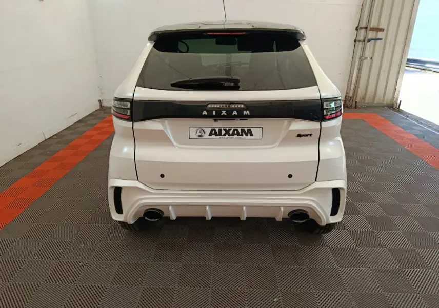 Vue arrière d'une Aixam Ambition 0.5 City Coupe Sport blanche, avec détails noirs et double sortie d'échappement.