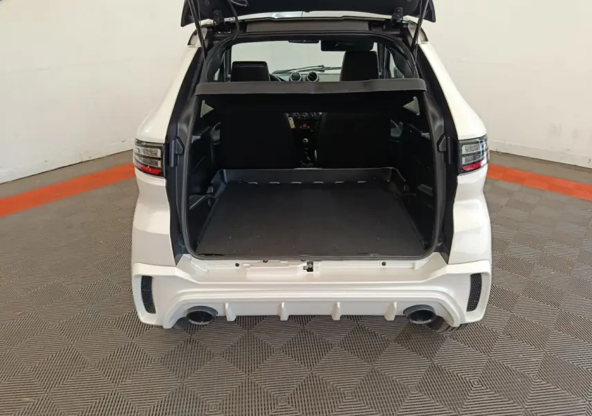 Vue arrière ouverte de l'AIXAM Ambition 0.5 City Coupe Sport blanc, coffre spacieux et double sortie d'échappement visible.