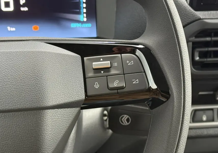 Gros plan sur les commandes au volant du Citroën Jumpy 2026, avec tableau de bord numérique en arrière-plan.