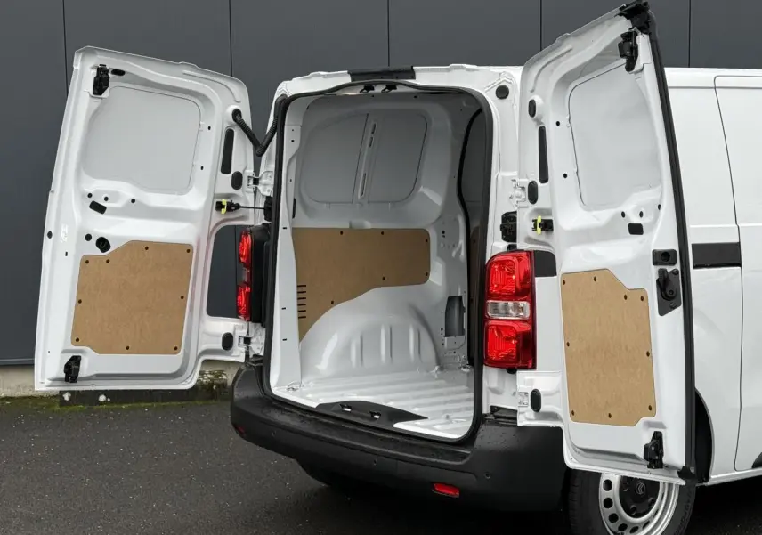Vue arrière du Citroën Jumpy blanc icy avec portes battantes ouvertes dévoilant l’espace de chargement vide et protégé.