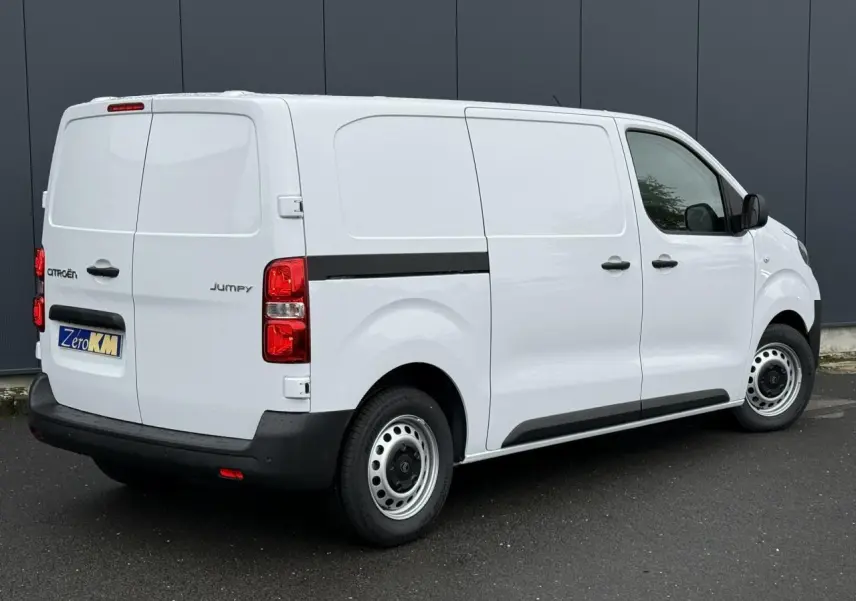 Vue 3/4 arrière droite du Citroën Jumpy blanc Icy, fourgon avec porte latérale coulissante et feux arrière rouges.