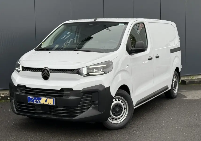 Vue 3/4 avant du Citroën Jumpy blanc Icy avec portes latérales et phares Full LED, stationné sur sol goudronné.