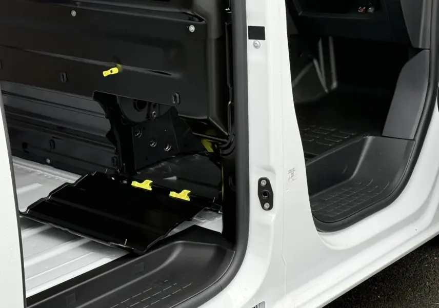 Vue rapprochée des portes latérales ouvertes du Citroën Jumpy blanc Icy, montrant l’intérieur utilitaire et les mécanismes de la porte.