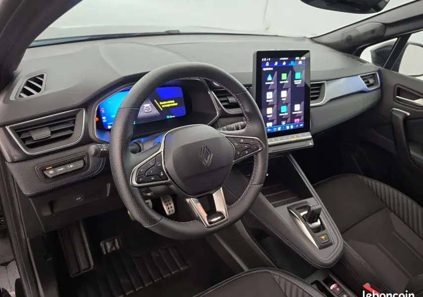 Vue intérieure côté conducteur du Renault Symbioz bleu 2025, volant multifonctions et grand écran tactile vertical au centre.