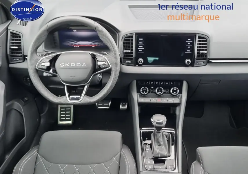 Intérieur avant du Skoda Karoq noir 2025, vue centrée sur le volant, tableau de bord et levier de vitesses automatique.