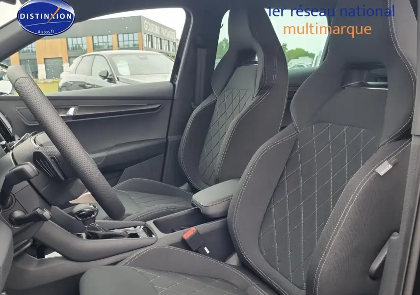Vue intérieure côté gauche montrant les sièges sport noirs avec surpiqûres blanches du Skoda Karoq 1.5 TSI 2025.