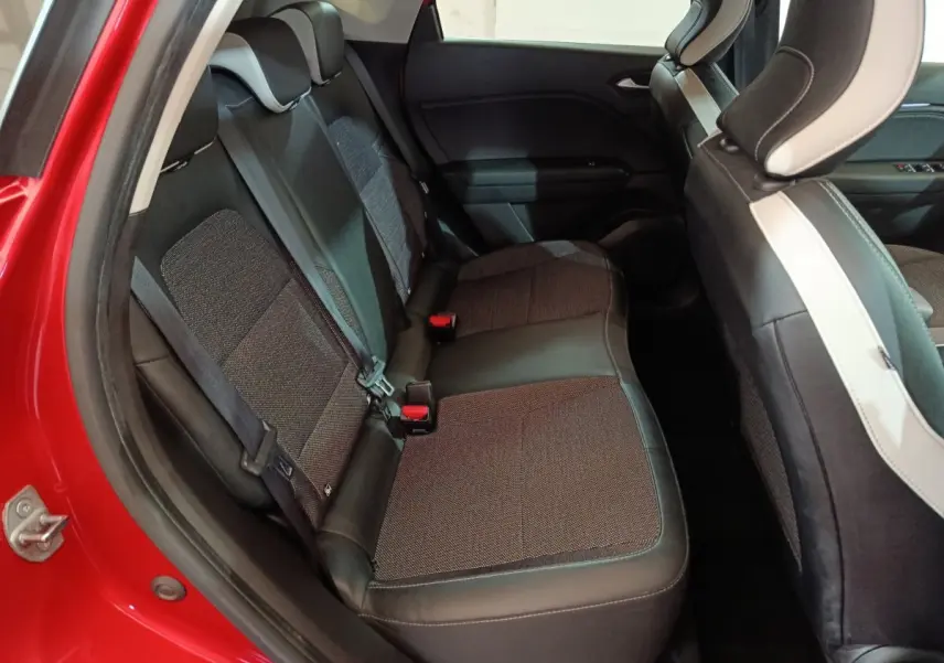 Vue côté gauche des sièges arrière en tissu et cuir du Renault Captur Techno TCe 90 rouge 2024, avec ceinture de sécurité visible.