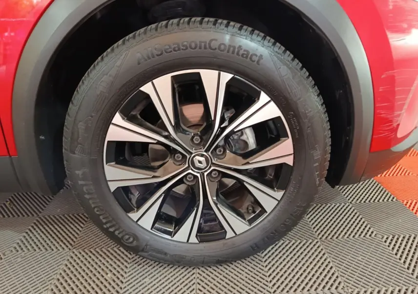Gros plan sur la roue avant gauche du Renault Captur rouge 2024 avec jante alliage bicolore et pneu Continental.