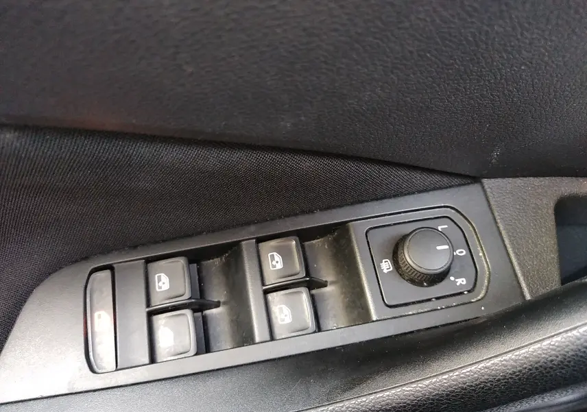 Commande des vitres et réglage des rétroviseurs côté conducteur dans une Skoda Kamiq 2023 gris, version Business.