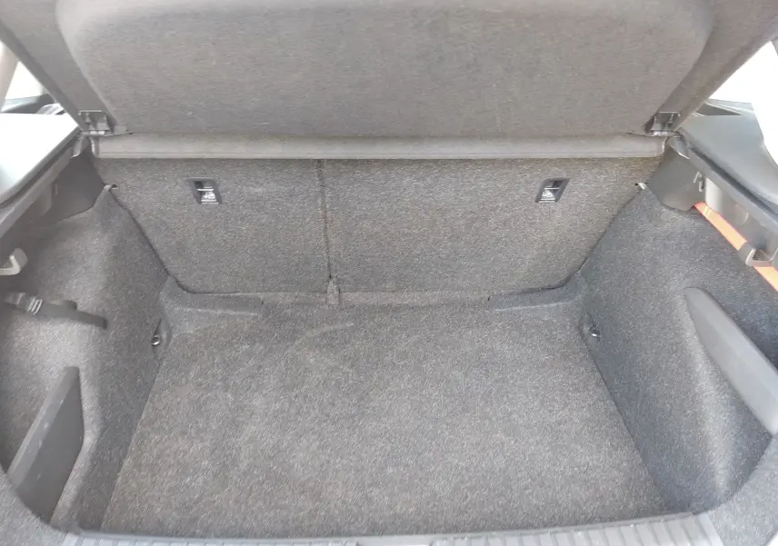 Coffre ouvert du Skoda Kamiq gris 2023, vue intérieure montrant l’espace de chargement tapissé de tissu gris.