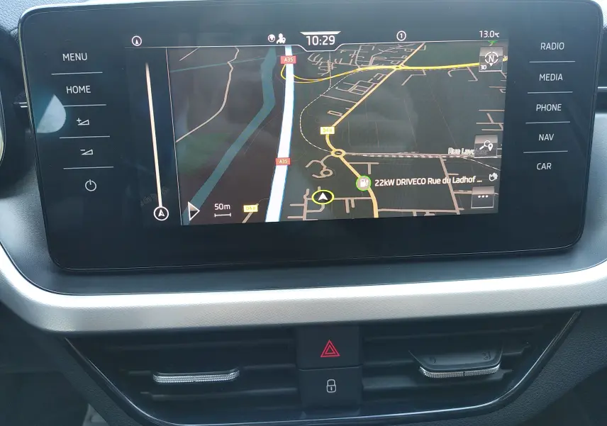 Écran tactile central du Skoda Kamiq 2023 gris, vue rapprochée du système de navigation avec commandes latérales.