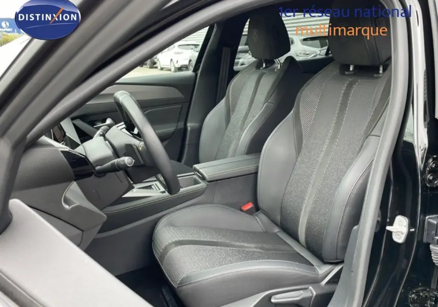Vue intérieure côté conducteur de la Peugeot 408 2025 noire, mettant en valeur les sièges en tissu et cuir gris avec volant multifonction.