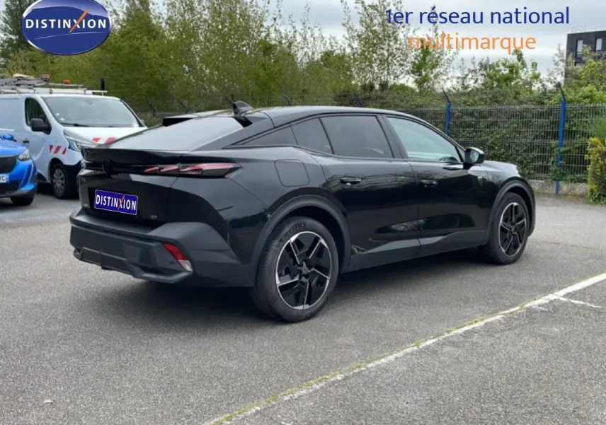Peugeot 408 noir métal vue 3/4 arrière droit, soulignant ses lignes fluides et ses jantes noires distinctives.