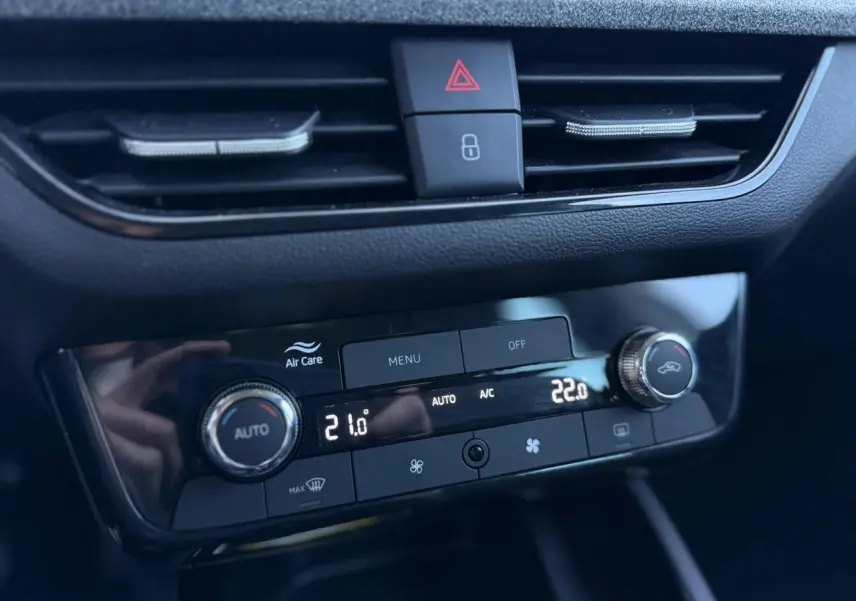 Gros plan sur la console centrale du Skoda Scala TSI 116, affichant la climatisation automatique bi-zone avec réglages numériques.