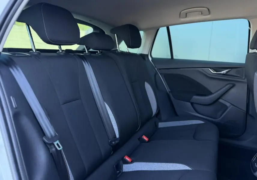 Vue intérieure côté droit des sièges arrière noirs avec surpiqûres grises d'une Skoda Scala TSI 116 Sélection Blanc Glacier 2025.