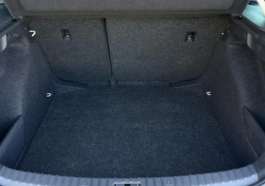 Coffre vide vu de face de la Skoda Scala TSI 116 blanc Glacier, avec revêtement intérieur gris foncé.