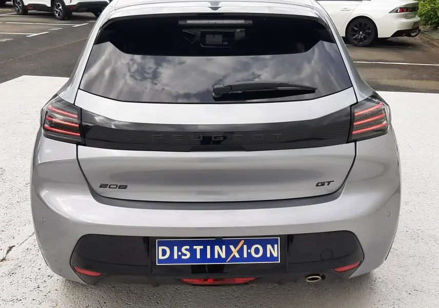 Vue arrière d'une Peugeot 208 GT gris Artense avec feux LED distinctifs et vitre arrière teintée.