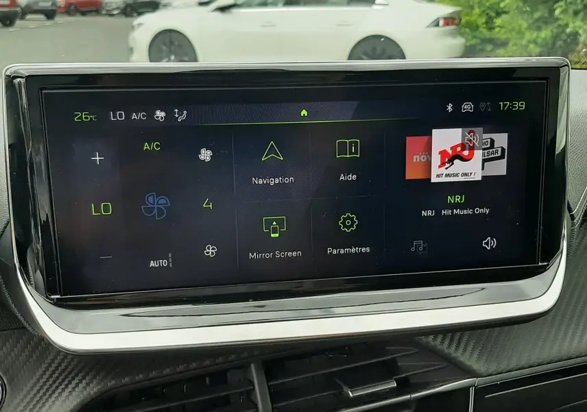 Vue intérieure centrée sur l'écran tactile multimédia de la Peugeot 208 1.2 100CH GT, avec commandes climatisation visibles.