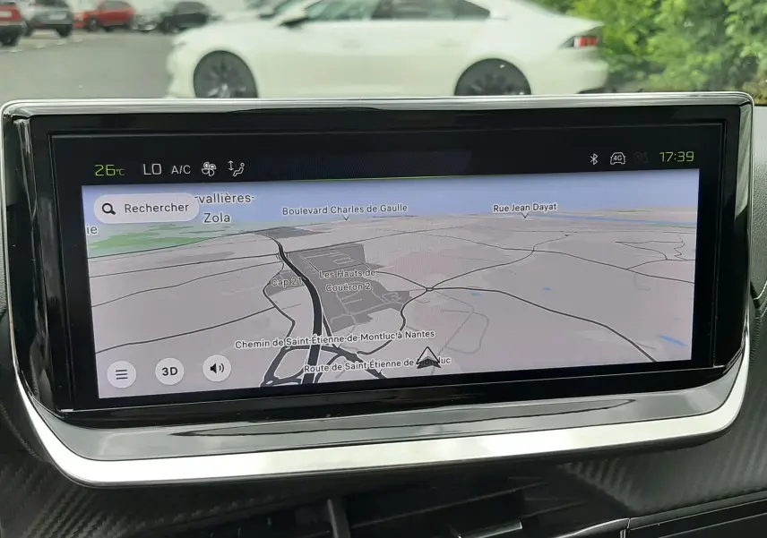 Écran tactile du système de navigation de la Peugeot 208 1.2 GT, vue intérieure centrée sur la carte GPS.