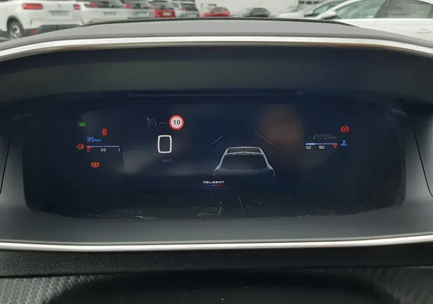 Affichage numérique du tableau de bord de la Peugeot 208 1.2 100CH GT, avec indicateurs de vitesse et alertes visibles.
