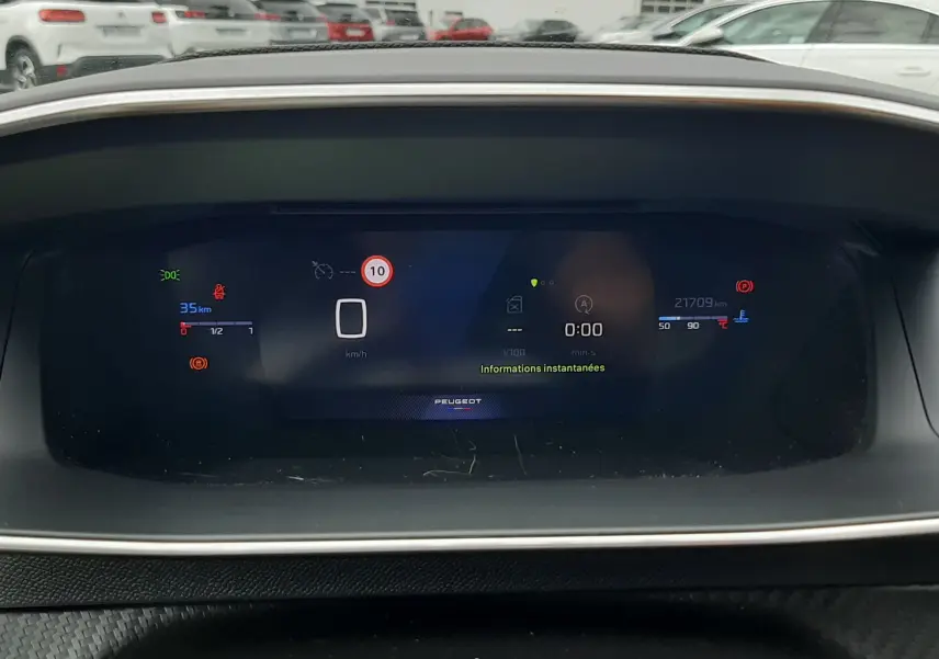Tableau de bord numérique de la Peugeot 208 gris Artense, affichant la vitesse à 0 km/h et les informations instantanées.