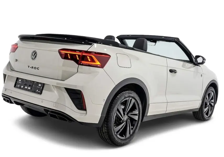 Vue 3/4 arrière droite d’un Volkswagen T-Roc Cabriolet beige métallisé avec capote ouverte et jantes noires distinctives.