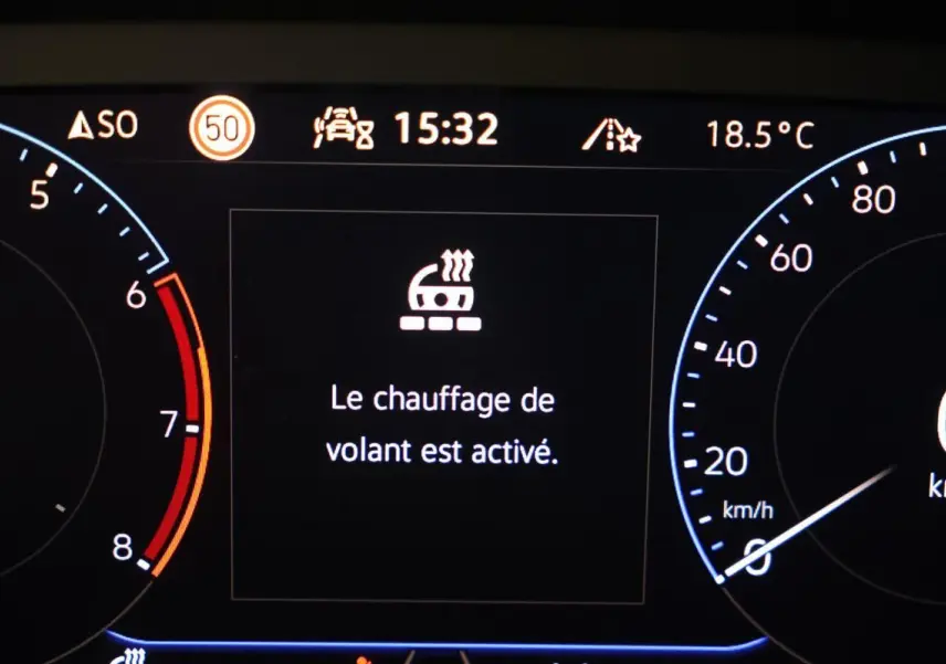 Tableau de bord numérique du Volkswagen T-Roc Cabriolet beige, affichant le chauffage du volant activé à 15h32.