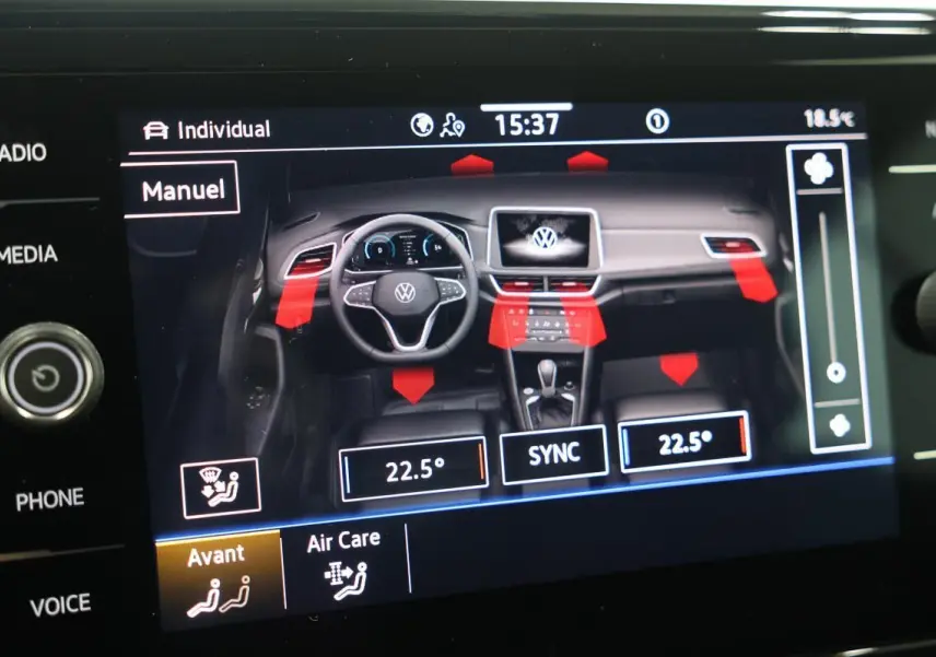 Vue intérieure du tableau de bord du Volkswagen T-Roc Cabriolet 2025 avec affichage digital et commandes climatisation.