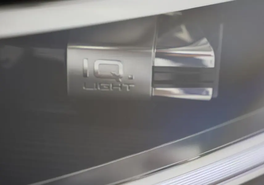 Gros plan sur le détail lumineux IQ.Light du Volkswagen T-Roc Cabriolet beige métallisé, mettant en valeur la technologie LED.