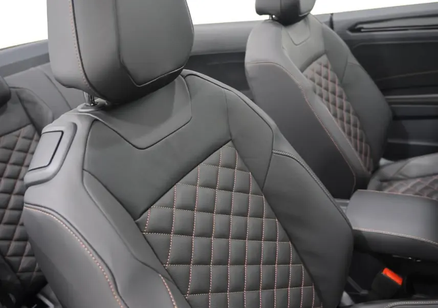 Gros plan sur les sièges avant en cuir noir avec surpiqûres marron, intérieur du Volkswagen T-Roc Cabriolet 2025.