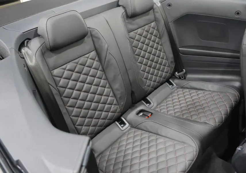 Vue rapprochée des sièges arrière en cuir noir matelassé du Volkswagen T-Roc Cabriolet beige métallisé 2025.