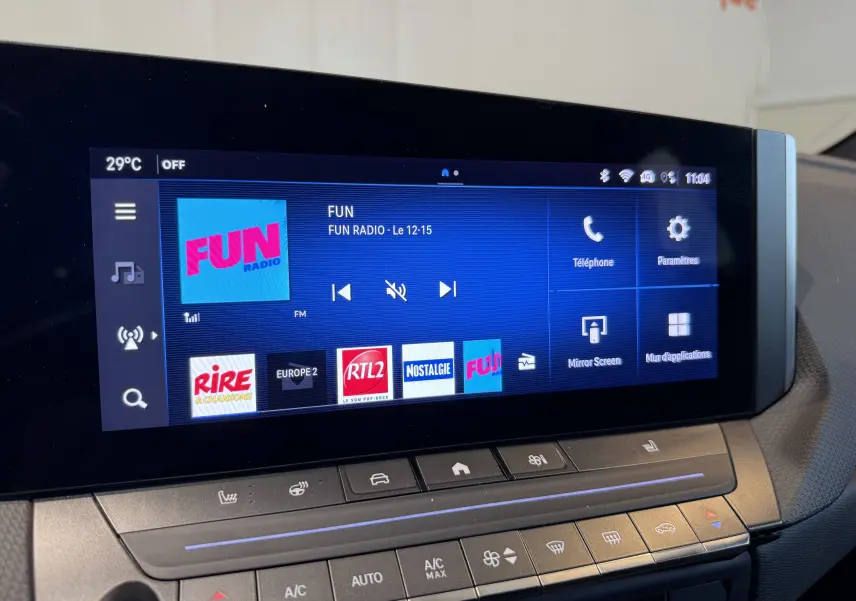 Détail intérieur de la console centrale de l’Opel Astra Sports Tourer 2024, bouton Drive Mode sur surface noire brillante.