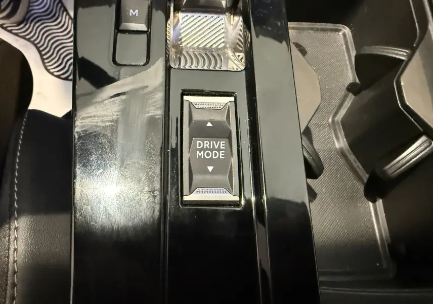 Gros plan sur la console centrale noire brillante de l’Opel Astra Sports Tourer 2024 avec commandes de boîte auto à boutons.